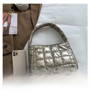 Detail of metallic quilted puffer tote bag with glossy finish and square stitch patterns