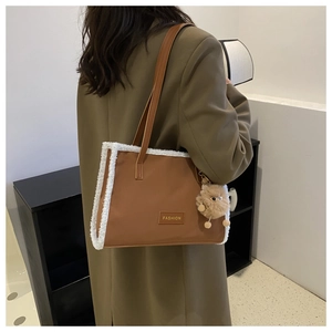 Gros plan d'un sac cabas marron avec bordure en molleton blanc et écusson fashion