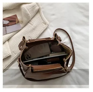 Top view of spacious interior in brown leather tote bag with daily essentials inside