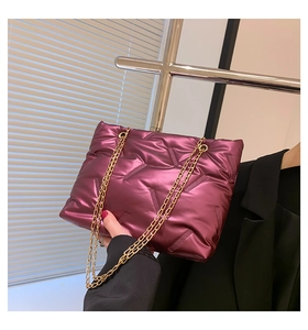 Detailaufnahme der lila gesteppten Puffer-Kettentasche mit Metallic-Finish und Goldkette