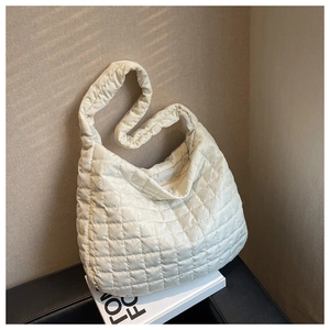 Detail of off-white quilted space cotton hobo bag featuring wide shoulder strap design