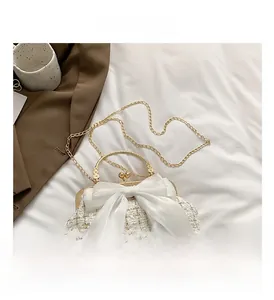 Detailed shot of tweed fabric texture and white organza bow on minimalist shoulder bag