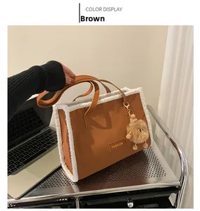 Détail du sac cabas marron avec bordure en fausse fourrure blanche et logo doré chic