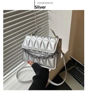 Silver glossy crossbody bag with triangular quilting and thick grey chain detail