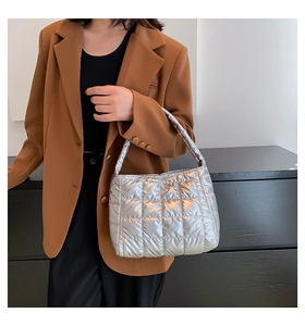 Detail of silver metallic puffer tote bag with quilted pattern and sleek padded handle