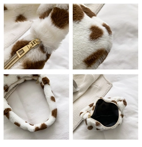 Detail of soft faux fur cow print handbag featuring premium metal zipper and black lining