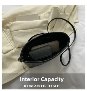 Interior view of black quilted shoulder bag showing capacity for phone and wallet