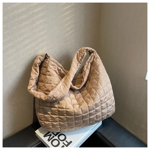 Detailed close-up of khaki quilted hobo bag with grid pattern and soft padded texture
