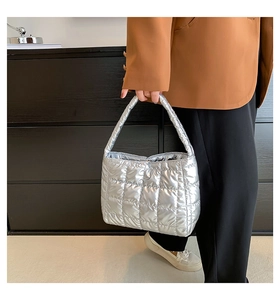 Close-up of silver quilted puffy tote bag featuring square stitch texture and metallic finish