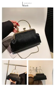 Details der schwarzen Vintage-Faltenhandtasche mit goldenem Metallgriff und Kette