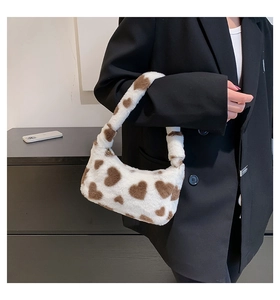 Detail of soft plush underarm bag featuring heart pattern and fuzzy faux fur texture