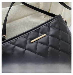 Detail of black quilted leather texture with gold metal buckle and precision stitching
