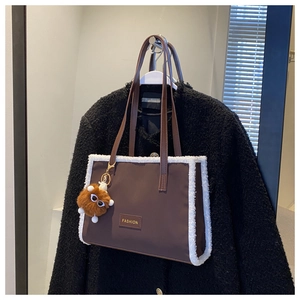 Détail du sac fourre-tout marron café avec bordure en fausse fourrure blanche et grigri