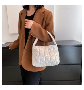 Close-up of white quilted puffer tote bag featuring glossy fabric and grid stitching details