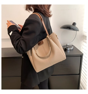 Detail of minimalist beige tote bag with slim shoulder straps for office commute styling
