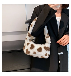 Furry handbag with heart pattern shown styled with a black blazer on a model