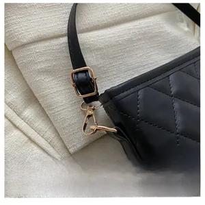 Detailed close-up of premium gold-tone metal hardware and black quilted leather strap