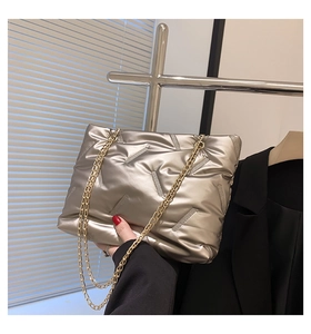 Detail der champagnerfarbenen Stepptasche mit Metallic-Finish und goldener Kette