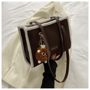 Détail d'un sac cabas marron avec bordure en polaire blanche et charm en peluche doux