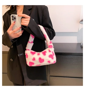 Plush heart pattern handbag worn with black suit to show texture and size