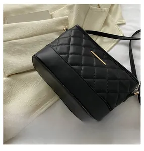 Detailed shot of the retro black quilted handbag with elegant gold metal bar accent