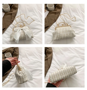 Macro view of white tweed handbag with golden metallic clasp and pearl bead handle