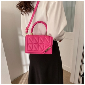 Detail of rose red PU leather crossbody bag with triangle quilting and woven handle