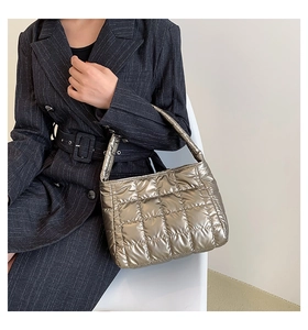Detail of metallic champagne quilted tote bag showing puffer texture and wide handle