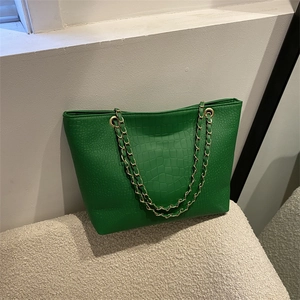 Green faux crocodile tote bag with gold chain straps and a minimalist design