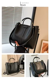 Detailed close-up of a large black leather tote bag with elegant golden hardware accents