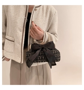 Detail of tweed evening bag with a satin bow and elegant vintage gold chain strap