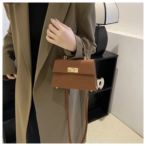 Detail of vintage brown crocodile embossed mini square bag with gold twist lock and handle
