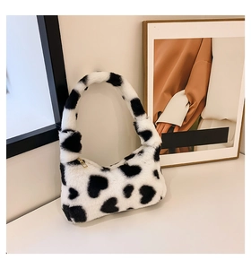 Detail of soft heart-patterned plush handbag with elegant gold metal zipper closure