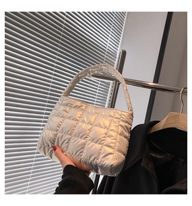 Detailed view of silver quilted tote bag with metallic texture and square puffer stitching