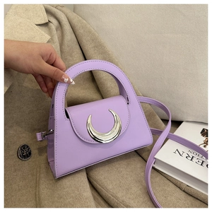 Detail of a purple leather handbag with a silver crescent metal buckle and shoulder strap
