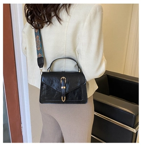 Model wearing a vintage black crossbody bag with a bohemian ethnic pattern strap