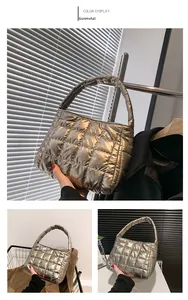 Detail of gunmetal quilted handbag featuring metallic finish and ruched handle design