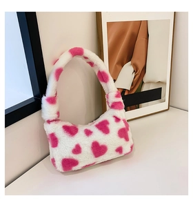 Detail of soft white faux fur handbag with pink heart print and plush handle