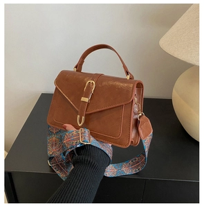 Brown retro handbag with gold buckle and a colorful bohemian embroidered shoulder strap