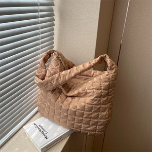 Champagne gold quilted puffer shoulder bag with a metallic finish and wide strap