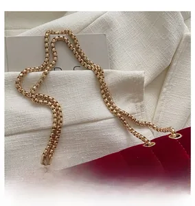 Macro detail of red velvet crossbody bag with premium gold chain strap and vertical quilting