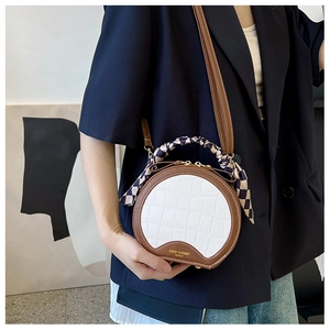 Fashionable round crossbody bag with crocodile texture and silk scarf handle detail