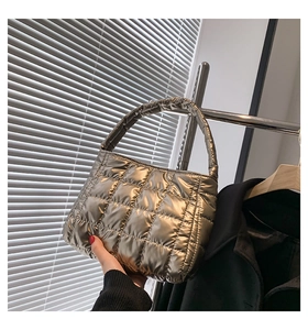 Detail of champagne gold quilted tote bag with metallic finish and ruffled handle