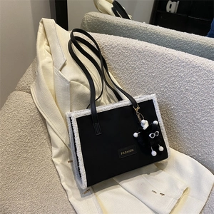Grand sac cabas en toile noire avec bordure en fausse fourrure blanche et étiquette