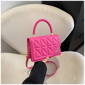 Detail of rose pink quilted crossbody bag with woven handle and gold hardware