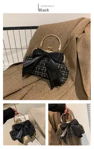 Detail of black tweed crossbody bag with satin bow and gold bead ring handle