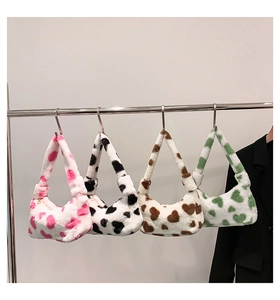 Multi-color plush hobo bags with heart prints displayed on a minimalist metal rack