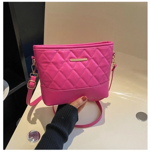 Detail of rose pink quilted crossbody bag with metal trim and zip closure