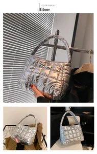Detailed close-up of silver quilted handbag with metallic finish and square stitching