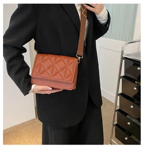 Caramel brown quilted crossbody bag detail with geometric patterns and golden hardware